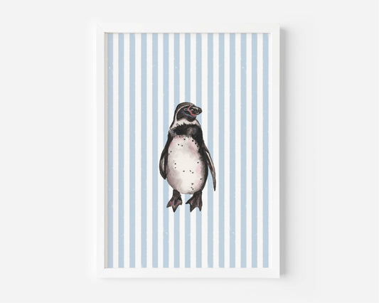A framed art print featuring a watercolor illustration of a penguin centered on a background of light blue and white vertical stripes, displayed against a clean white wall.