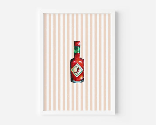 A framed art print featuring a watercolor-style illustration of a red hot sauce bottle centered on a background of vertical peach and white stripes, set against a clean white wall.