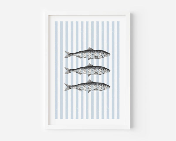 A framed art print featuring three horizontal fish illustrations over vertical light blue and white stripes, displayed in a white frame against a light gray wall.