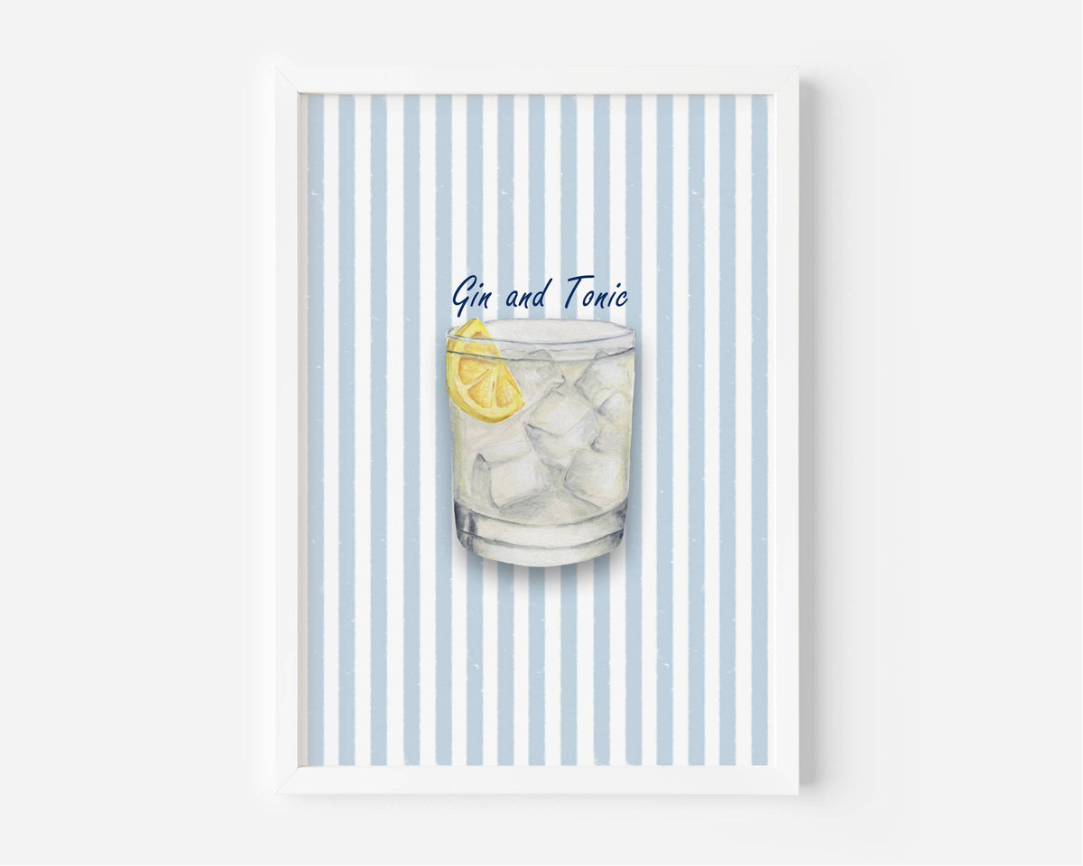 A framed art print featuring a watercolor illustration of a Gin and Tonic cocktail with a lemon slice, set against a background of light blue and white vertical stripes.