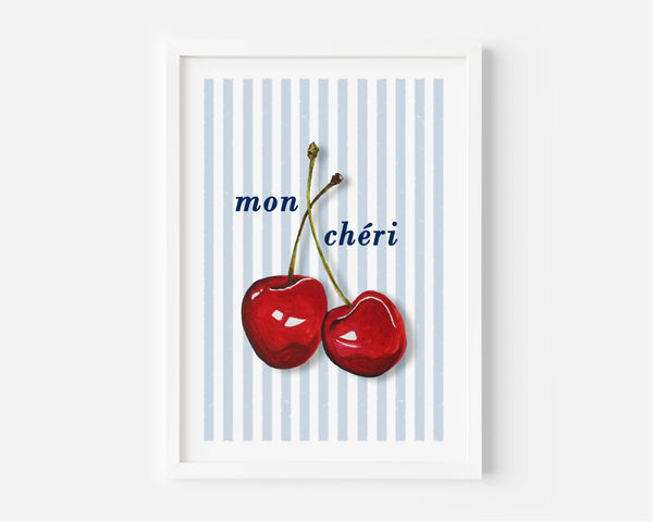 A framed wall art print featuring two glossy red cherries on a white background with light blue vertical stripes and the text 'mon chéri' in dark blue script. The frame is white and shown against a light gray wall.