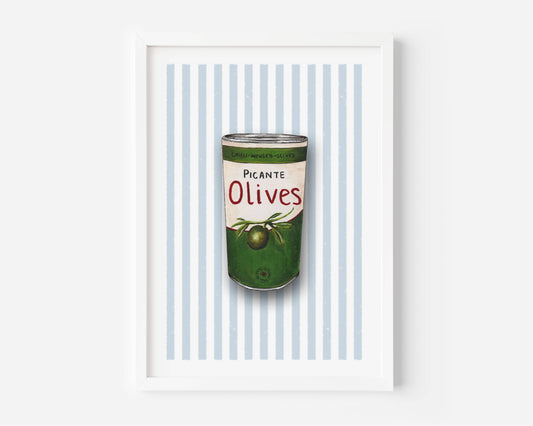 A framed art print featuring a vintage-style illustration of a green can of olives with the text 'Picante Olives' on a background of light blue and white vertical stripes, set against a clean white wall.