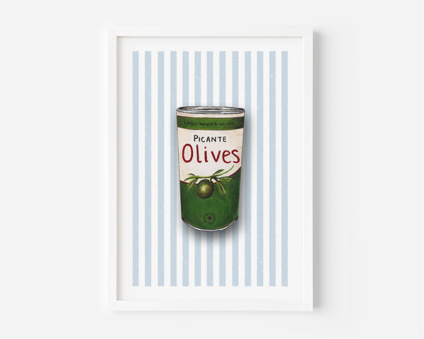 A framed art print featuring a vintage-style illustration of a green can of olives with the text 'Picante Olives' on a background of light blue and white vertical stripes, set against a clean white wall.