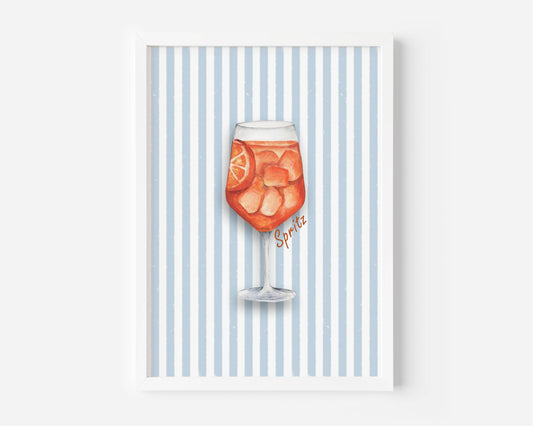 A framed art print featuring a watercolor illustration of a glass of orange soda with ice and a lemon slice, set against a background of vertical light blue and white stripes. The word 'Spirits' is written in a cursive font near the glass.