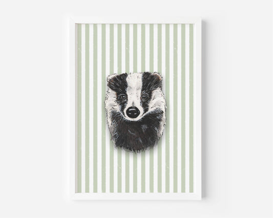 A framed art print featuring a black and white sketch of a badger's face centered on a background of vertical sage green and white stripes, displayed on a clean white wall.