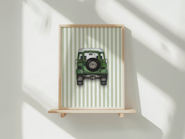 A framed art print featuring a green vintage jeep on a light green and white striped background, displayed on a light wood shelf against a white wall with soft window shadows.