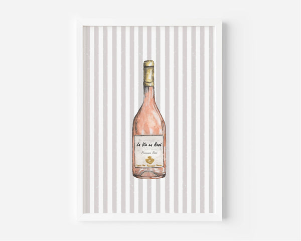 A framed art print featuring a watercolor illustration of a pink wine bottle against a background of vertical gray and white stripes, displayed on a clean white wall.