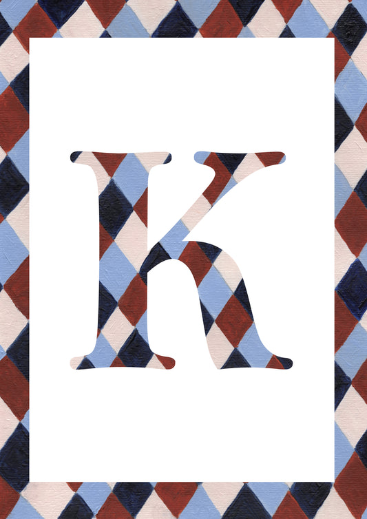 A decorative letter K monogram with a harlequin diamond pattern in navy, light blue, burgundy, and cream, set against a white rectangular field with a matching patterned border.