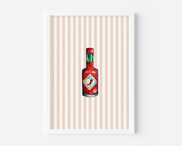 A framed art print featuring a watercolor-style illustration of a red hot sauce bottle centered on a background of vertical peach and white stripes, set against a clean white wall.