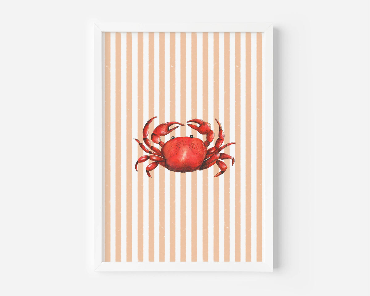 A framed art print featuring a red watercolor crab centered on a background of vertical peach and white stripes, displayed against a light gray wall.