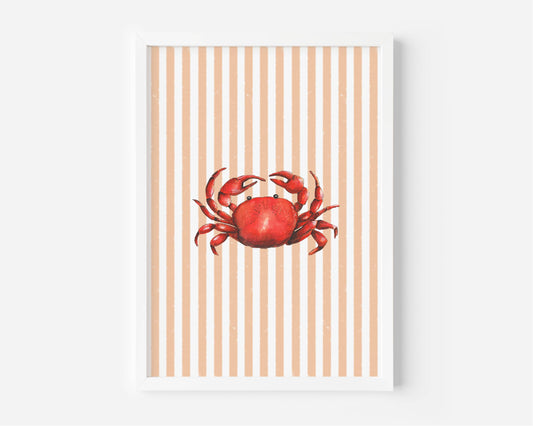 A framed art print featuring a red watercolor crab centered on a background of vertical peach and white stripes, displayed against a light gray wall.