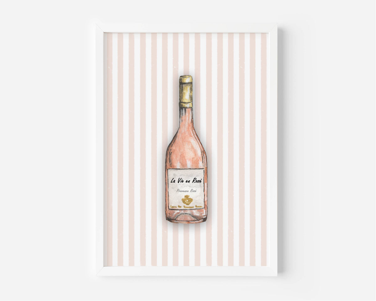 A framed art print featuring a watercolour illustration of a pink wine bottle on a background of vertical light pink and white stripes, displayed against a clean white wall.