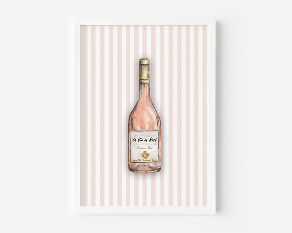 A framed art print featuring a watercolour illustration of a pink wine bottle on a background of vertical light pink and white stripes, displayed against a clean white wall.