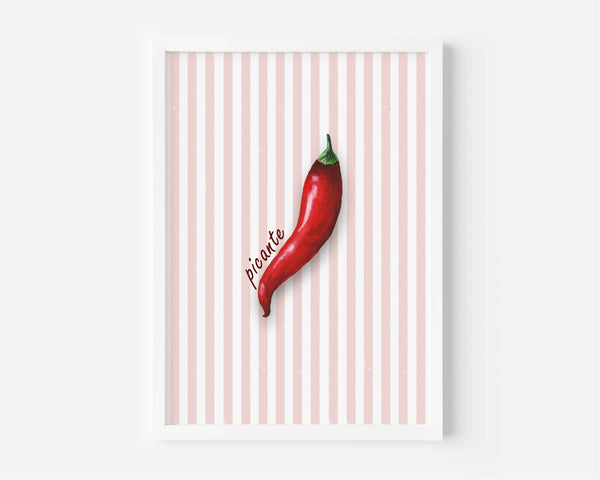 A framed wall art print featuring a single red chili pepper on a white and pale pink striped background, with the word 'picante' written in script. The print is shown in a white frame against a light gray wall.