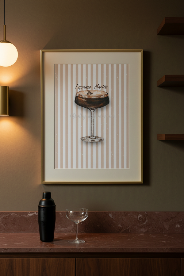 A framed art print featuring an illustration of an espresso martini on a cream and brown striped background, displayed on a dark brown wall above a bar counter with a shaker and a coupe glass.