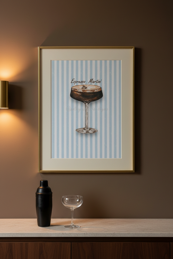 A framed art print featuring an illustration of an espresso martini on a light blue and white striped background, hanging on a dark brown wall above a counter with a cocktail shaker and a coupe glass.