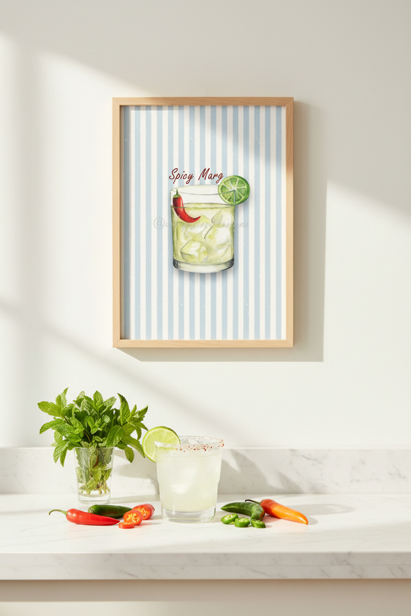 A framed art print featuring a colorful illustration of a spicy margarita with a striped blue and white background, hanging on a white wall above a marble countertop with fresh herbs, a margarita glass, and chili peppers.