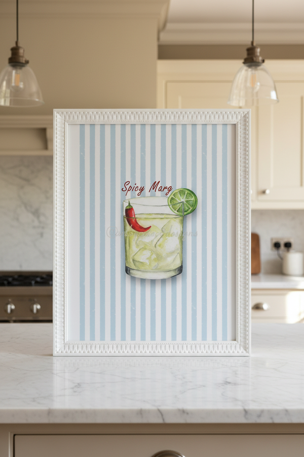 Spicy Marg watercolour art print in a white bobble frame, hung on a wall in a Georgian kitchen with Shaker cabinetry and warm pendant lighting.